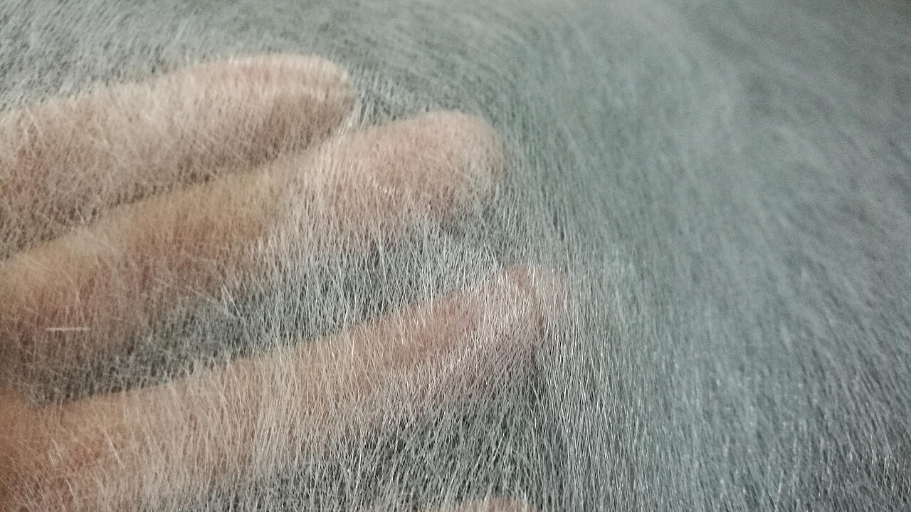 Hand leicht verschwommen hinter Glasfasergewebe